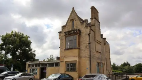 Cotswold District Council The Old Station in Cirencester with cars parked at the front