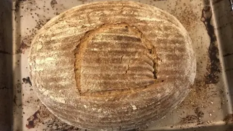 Maximilian Blackley Baked loaf scored with hieroglyph meaning "bread"