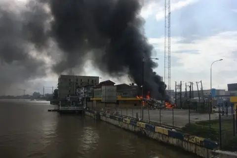 Getty Images A building on fire next to open water