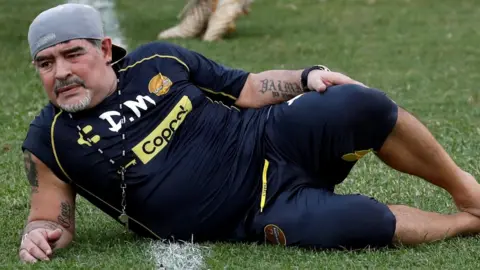 Reuters Diego Maradona rests on the ground after delivering training