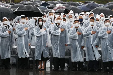 Chung Sung-Jun / Getty Images South Korean President Yoon Suk-yeol and his wife Kim Keon-hee salute during a ceremony marking Korean Memorial Day at the Seoul National cemetery on 6 June, 2022 in Seoul, South Korea