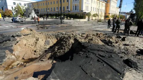 Getty Images A crater in the road in Kyiv