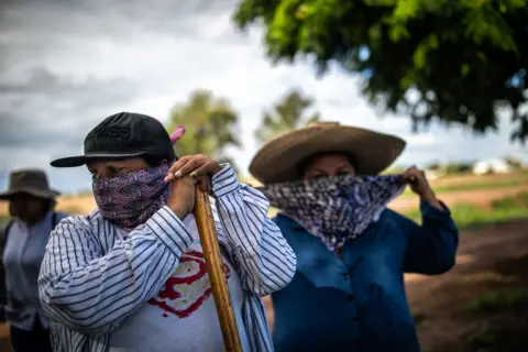 ALEJANDRO CEGARRA Juana Escalante, left, gets ready for a search near a farm where a horseman reported the smell of decomposition