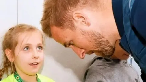 PA Media/Nick Passey Caitlin Passey with Harry Kane