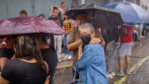 EPA Citizens wait in line to vote in the opposition primary elections, in Caracas, Venezuela, 22 October 2023