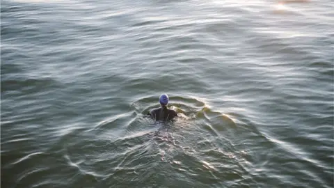 Getty Images A person swimming in a wetsuit