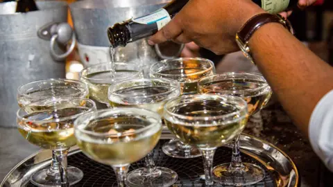 Getty Images Bubbly being poured into tray of coupes