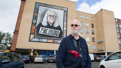 Martin Shields Billy Connolly next to one of his murals