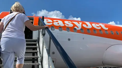 AFP/Getty Images Passenger boards an EasyJet domestic flight at an airport in the United Kingdom on June 15, 2020