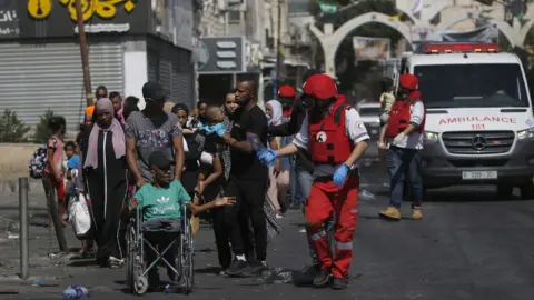 EPA Palestinian Red Crescent staff evacuate Palestinian civilians from the Jenin refugee camp (4 July 2023)