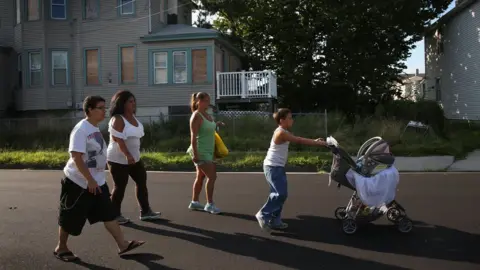 Getty Images A group walks past a boarded-up house in Atlantic City