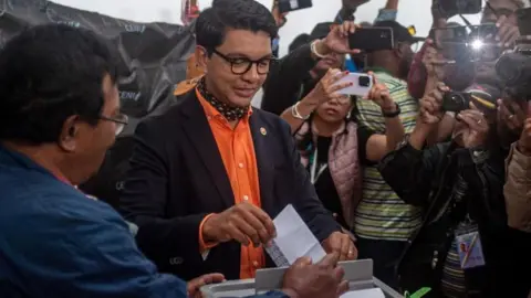 Getty Images Madagascar President Andry Rajoelina (C) casts his vote for the presidential election at Ecole Agricole Ambatobe, in Antananarivo, Madagascar, 16 November 2023