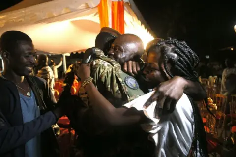 EPA One of the 46 Ivorian soldiers who was arrested in July in Mali is welcomed by his family after a ceremony at Abidjan airport, in Ivory Coast - Saturay 7 January 2023