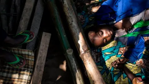 AFP A boy rests with other Internally Displaced Persons (IDP's) as they wait for their daily food ration in a site for IDP's fleeing the conflict in the Kasai Province on June 7, 2017 in Kikwit