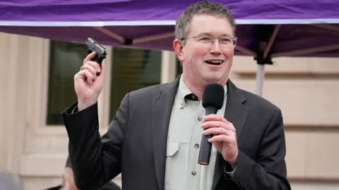 Getty Images Rep. Massie draws a handgun from his pocket during a rally in support of the Second Amendment on January 31, 2020