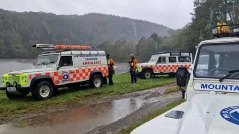 Rescue vehicles by river's edge