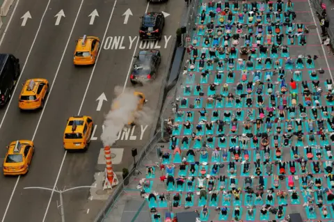 Lucas Jackson / Reuters People participate in a yoga class during an annual Solstice event in the Times Square district of New York