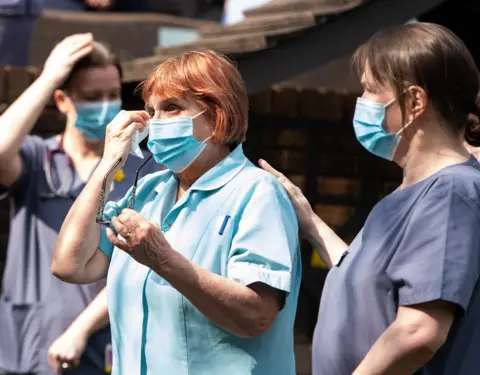 Polly Thomas / Getty Images Staff of a Marie Curie hospice take part in a minute's silence