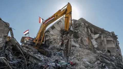 EPA An Egyptian team works to remove the rubble of destroyed buildings in Gaza City (5 June 2021)