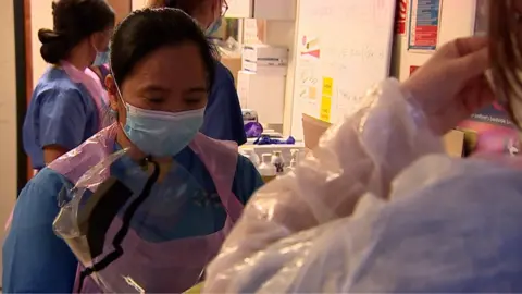 NHS staff putting on protective equipment