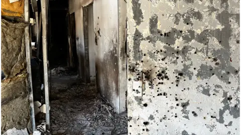 A metal door is punctured with countless bullet holes around the lock. It leads to a scorched corridor filled with debris