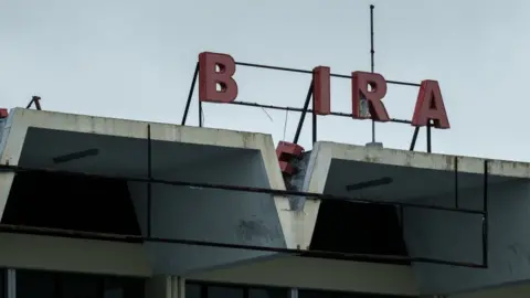 AFP A picture taken on 20 March 2019 shows the letter 'e' ripped away from Beira's international airport.