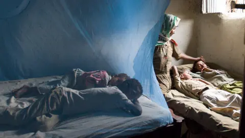 Getty Images A mother in Ethiopia who doesn't have enough anti-malarial bed nets for all of her children