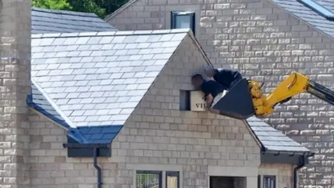 HSE Workers standing in the bucket of a digger at The Villas