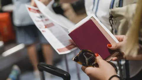 Getty Images Woman holds passport