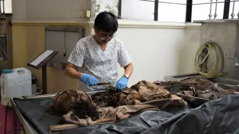 BBC/TIM MANSEL Forensic pathologist Raquel Fortun examines bones of Duterte drug war victims in Manila