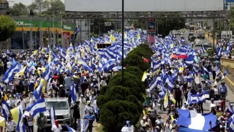 Reuters Demonstrators hold national flags during a march in support of the Catholic Church in Managua, Nicaragua July 28, 2018