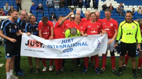 BBC The England team raise the trophy after the game