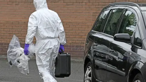 Alan Lewis Police remove the remnants of a device from Clandeboye Drive