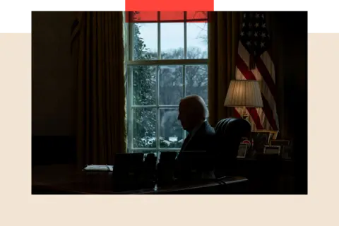 EPA President Joe Biden receives a briefing at his desk in shadows