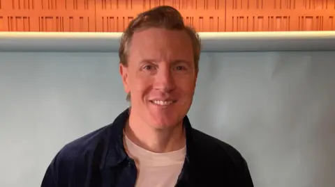 Patrick smiling in the studio as a guest on Ready to Talk