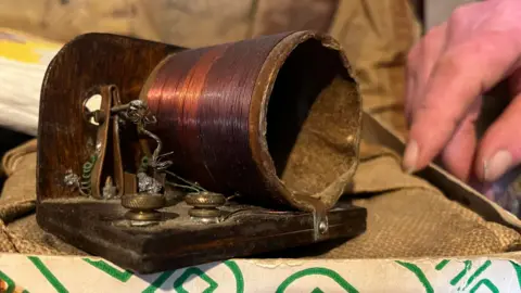 A crystal radio device, with copper lining and wooden platform.