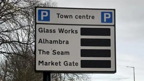 A road sign directing drivers to town centre car parks at Glass Works, Alhambra, The Seam and Market Gate.