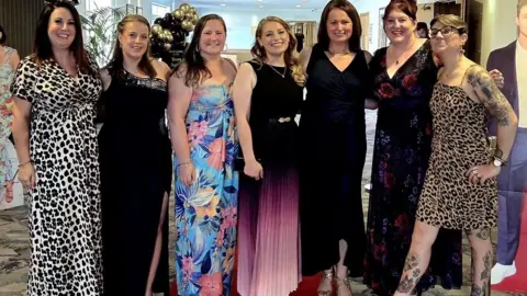 Supplied A group of women stood up in full-length occasion dresses
