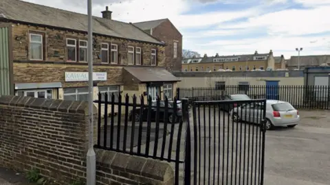 A two-storey stone building in Keighley with a car park in front of it.