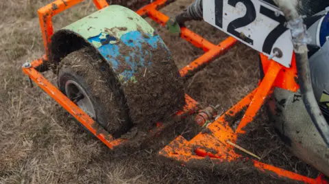 Harry George Hall Muck on the wheels and mudguards of a lawn mower racing machine