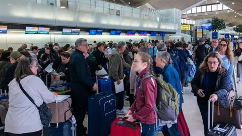 People wait in line for a delayed flight at Newark International Airport on 05 May  in Newark, New Jersey