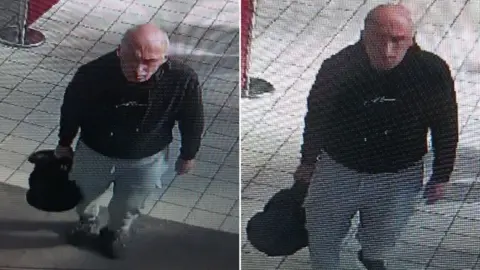 Handout Two CCTV stills of a man in a black hoodie with grey bottoms carrying a black duffle bag.