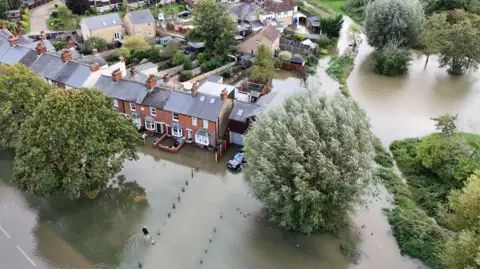 EPA-EFE/REX/Shutterstock An aerial picture shows terraced housing surrounded by floodwater.