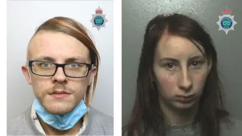 A composite of police mugshots of Jack William Davies and Terrie Marie Wood. Davies is wearing glasses and a grey jumper and has a blue facemask around his chin. Davies has long dark hair and is wearing a grey jumper.