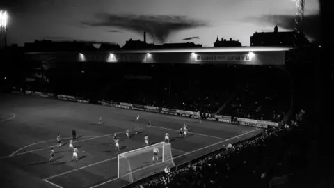 Ian Beesley A black-and-white shot of Bradford City's home ground Valley Parade taken from a distance back in the stands.