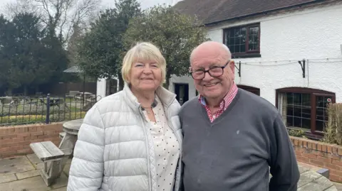 Phil and Sheila standing in front of The Coach and Horses