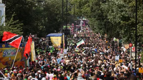 PA Media Revellers attend Notting Hill Carnival, in London, with huge crowds gathering for the annual celebration