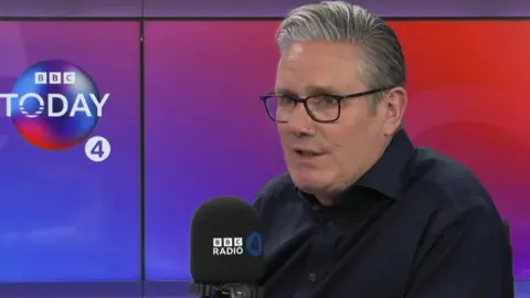 Sir Keir Starmer speaking into a radio microphone in front of a BBC Radio 4 backdrop.