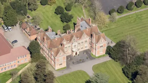 English Heritage/Getty Images An aerial view of Shaw House, an Elizabethan mansion, and surrounding grounds, and a neighbouring building to its left. 