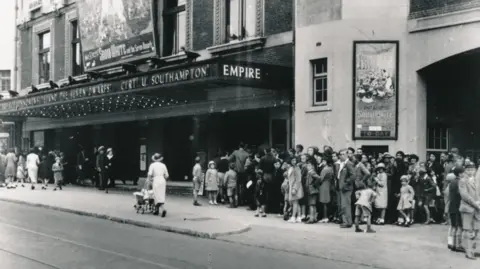 Mayflower Theatre An archive black and white picture of the Empire Theatre dating from the 1930s with crowds outside queuing for a production of Snow White, advertised above the front entrance.